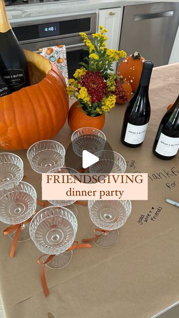 a table with wine glasses and pumpkins on it