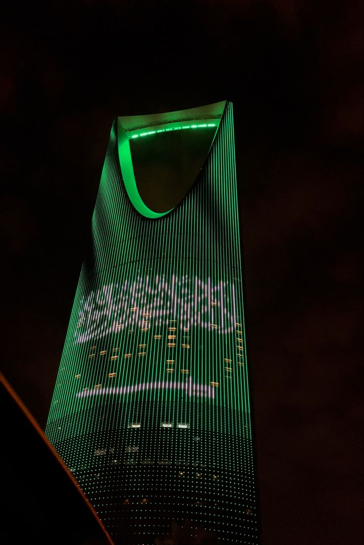 a very tall building lit up with green lights