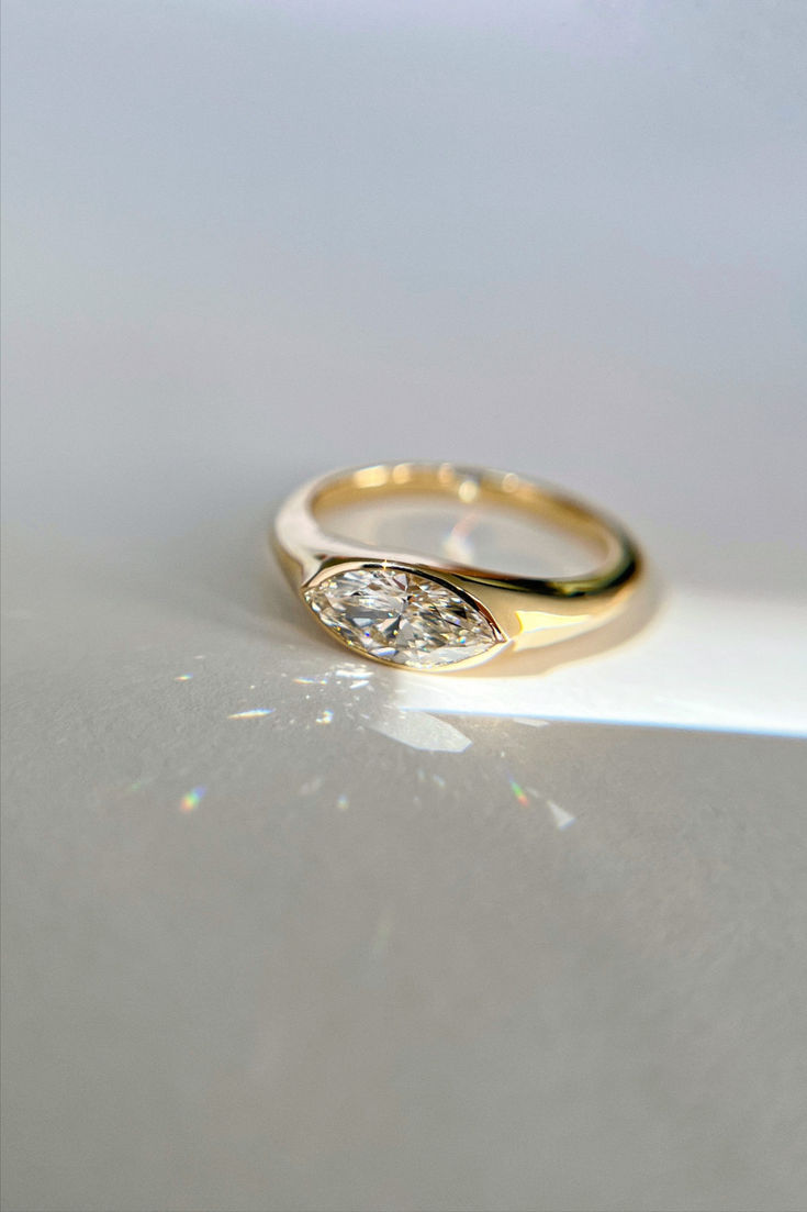 a gold ring with two diamonds on it