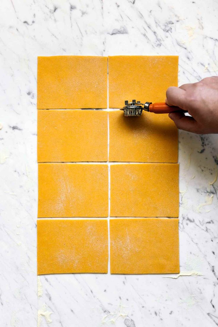 a person is using a brush to paint yellow tiles