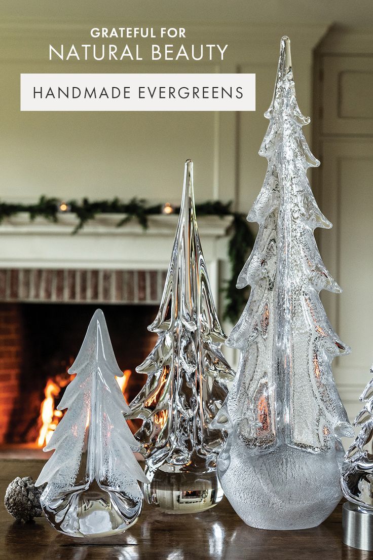 three glass christmas trees on a table in front of a fireplace with the words, grateful for natural beauty handmade evergreens