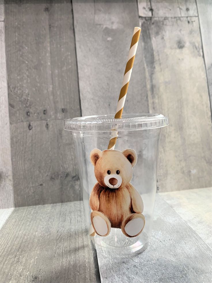 a plastic cup with a teddy bear on it and a straw sticking out of the top