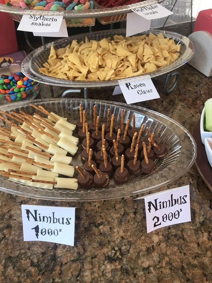 there are many different types of snacks on the table together in trays with name tags