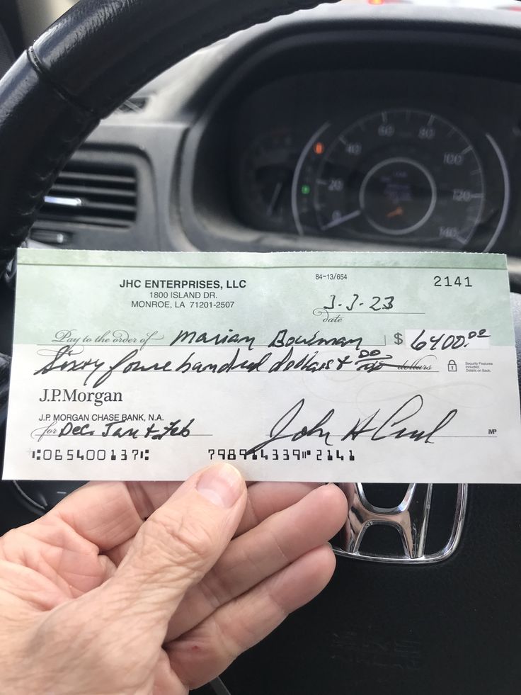 the driver's hand is holding up a cheque