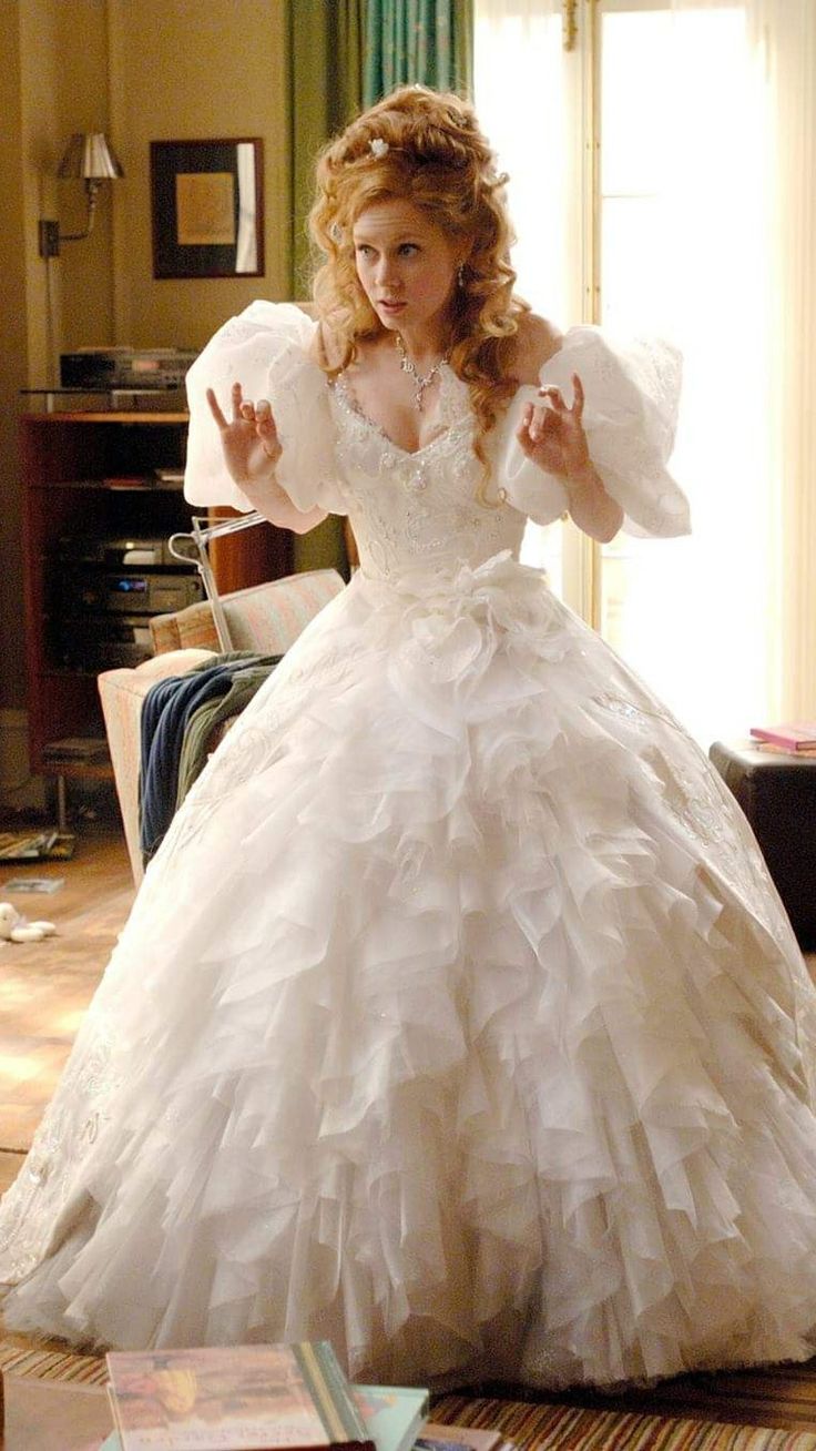 a woman in a white wedding dress is posing for the camera with her arms outstretched