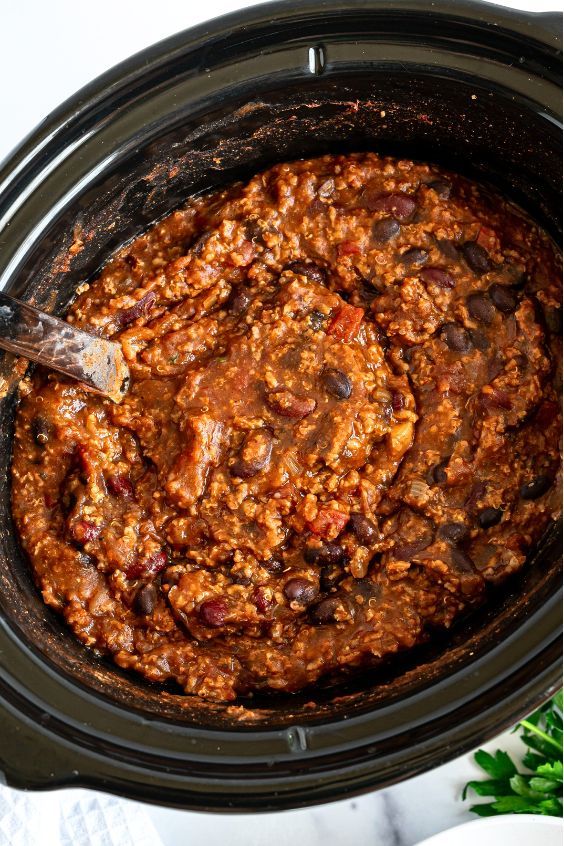 a slow cooker filled with chili and meat in the crock pot, ready to be cooked