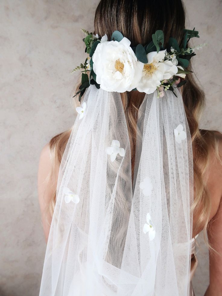 a woman wearing a veil with flowers on it