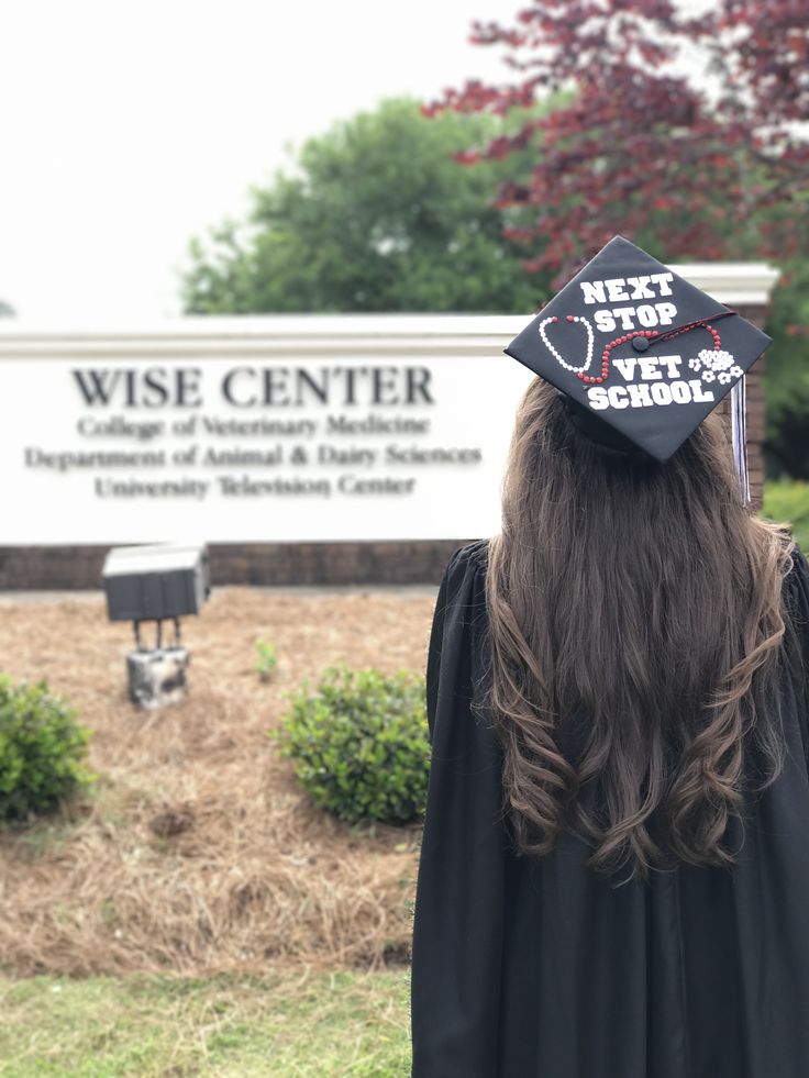 a person wearing a graduation cap and gown in front of a sign that says wise center