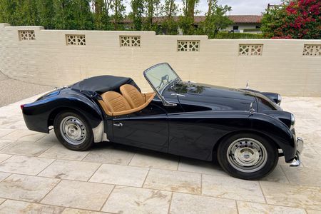 a black sports car parked in front of a wall