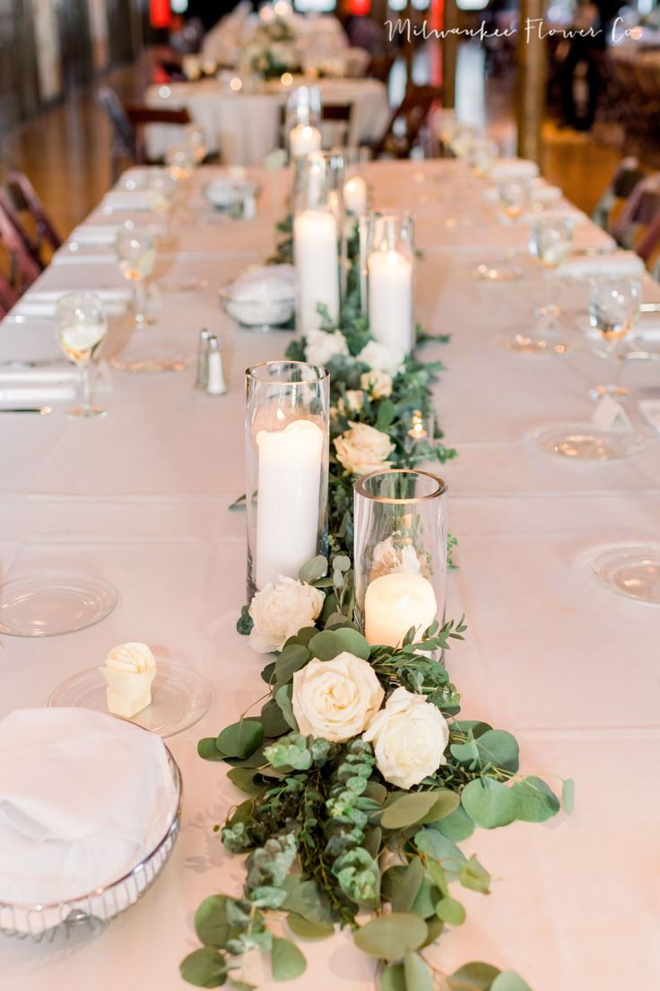 a long table with candles and flowers on it is set up for a formal dinner