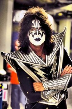 a man with his face painted like a kiss band member, posing for a photo