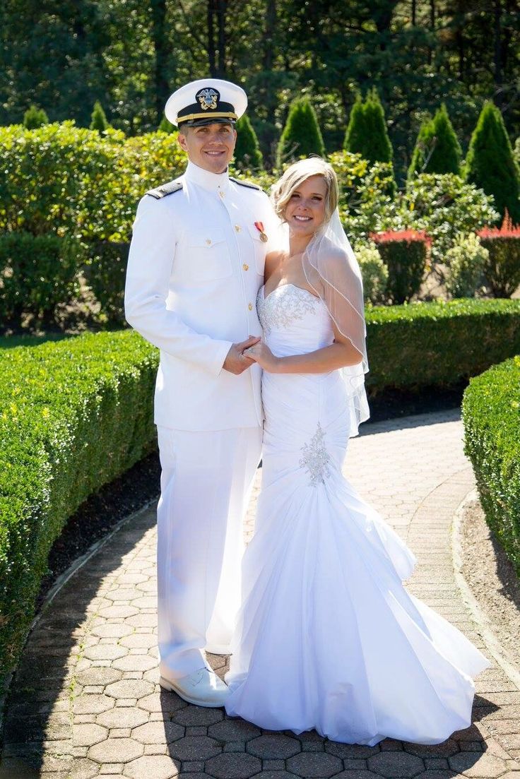 a man and woman dressed in white posing for a photo