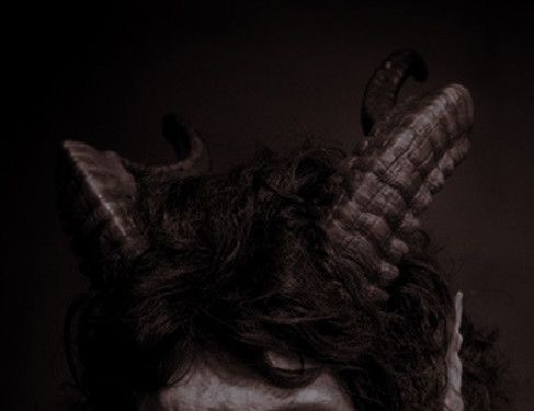 a man with long hair and horns on his head