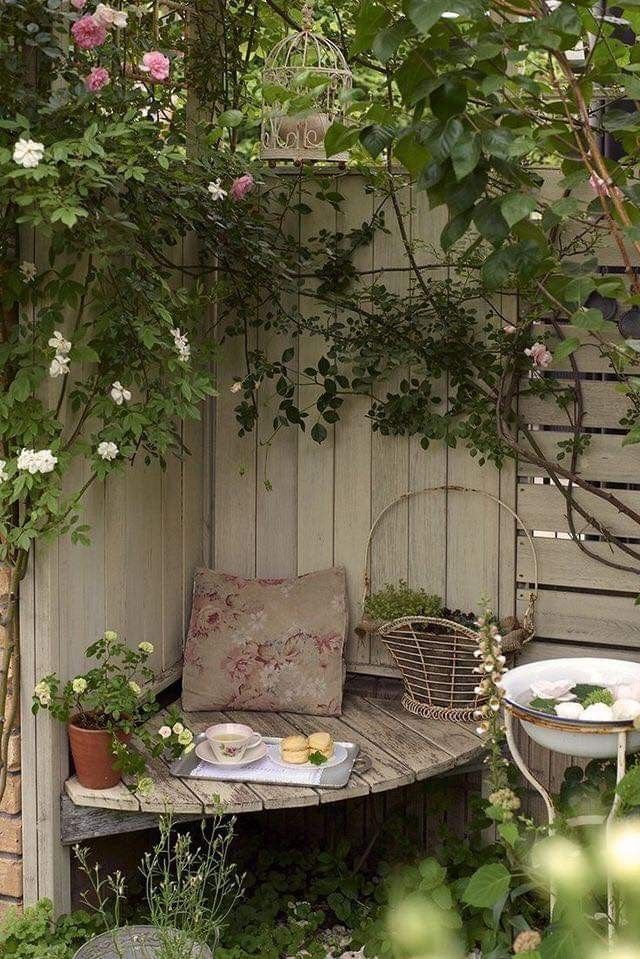 an outdoor table and bench with flowers on it