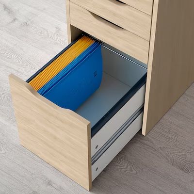 an open file cabinet with files and folders in the bottom drawer, on a wood floor