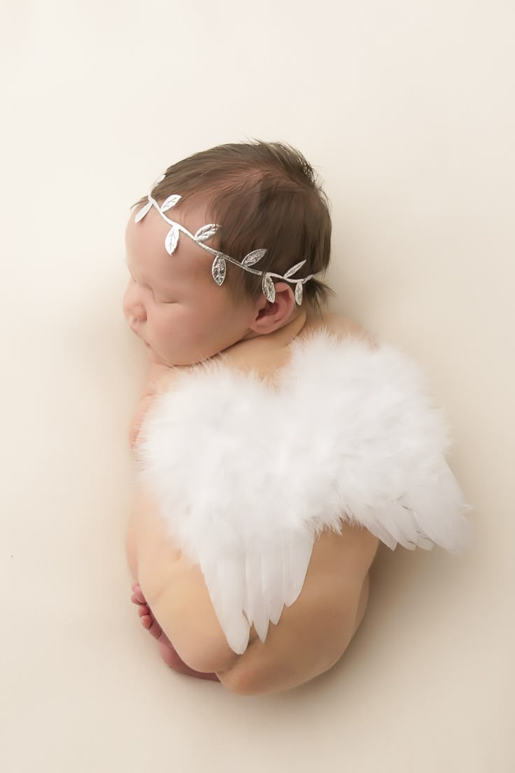 a newborn baby with angel wings on it's head