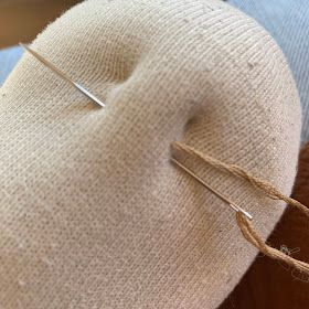 a pair of needles are hooked up to the back of a pillow