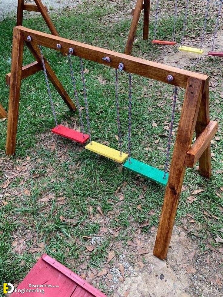 a child's wooden swing set in the grass