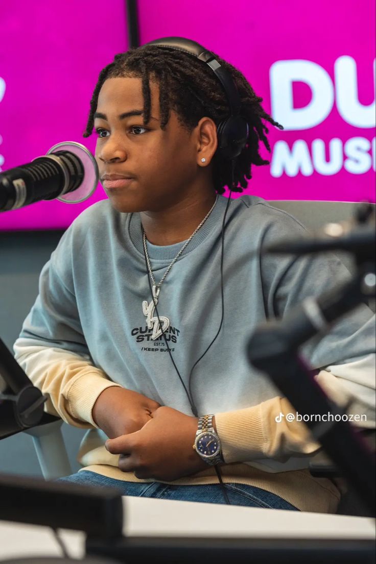 a woman with headphones sitting in front of a microphone