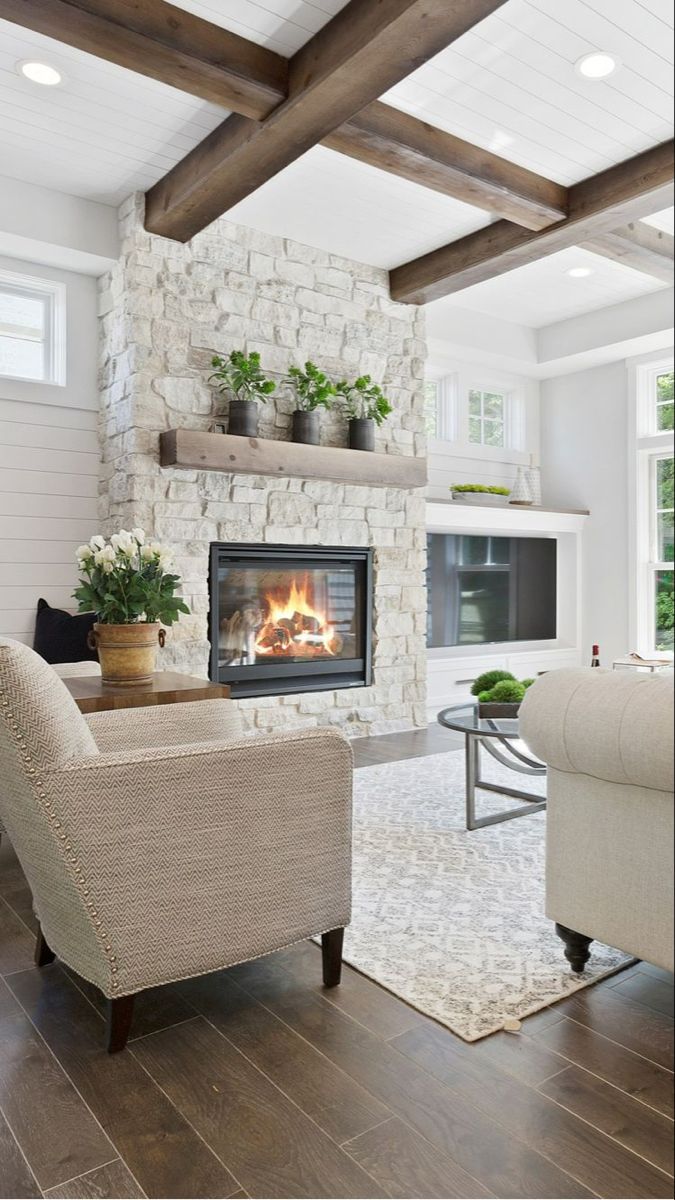 a living room filled with furniture and a fire place in the middle of the room