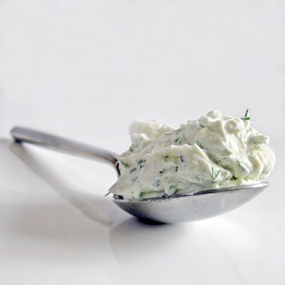 a spoon filled with whipped cream on top of a white table