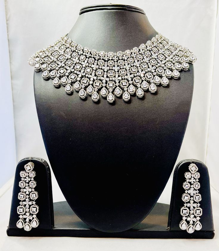 American Diamond Bridal Necklace Set--a perfect blend of elegance and contemporary design, ideal for your special day. Despite its dramatic appearance, the necklace is lightweight, ensuring comfort while wearing it throughout your special day. his necklace pairs beautifully with traditional outfits like lehengas and sarees, as well as modern gowns, adding a touch of glamour to any look Dazzling Bridal Necklace For Reception, Silver Diamond Necklace For Wedding And Festive Occasions, Heavy Dazzling Necklace For Formal Occasions, Festive Silver Diamond Necklace For Wedding, Dazzling Silver Bridal Necklace With Intricate Design, Dazzling Silver Bridal Necklace For Festive Occasion, Dazzling Silver Necklace For Festive Occasions, Festive Silver Elegant Bridal Necklace, Dazzling Silver Festive Necklace