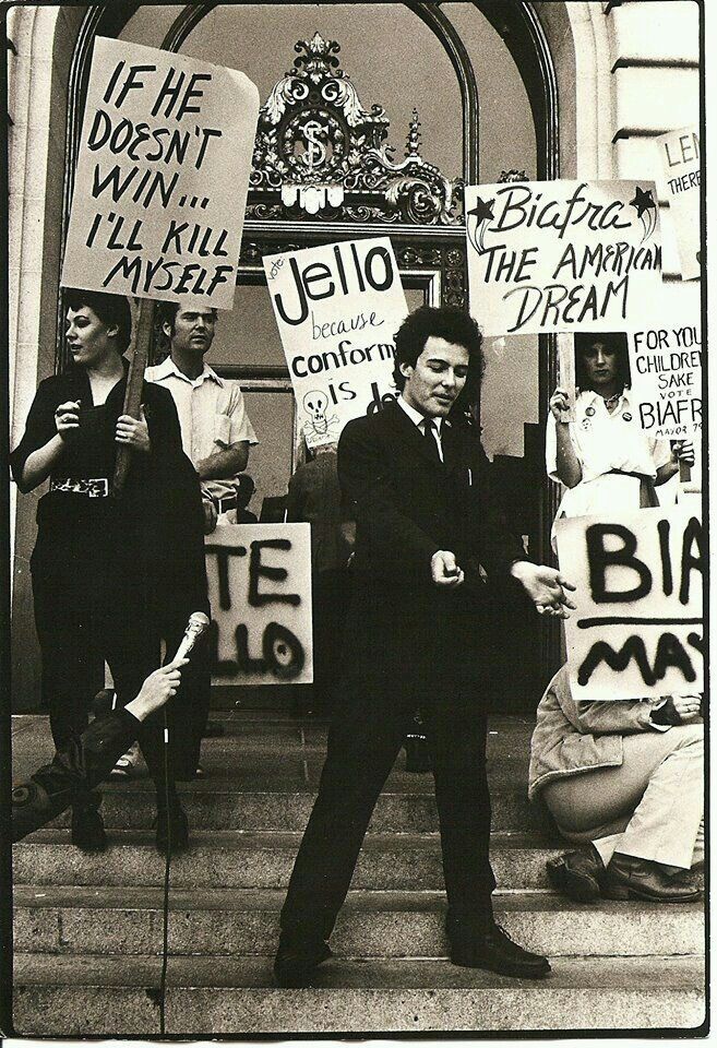 black and white photograph of people holding protest signs on the steps in front of a building