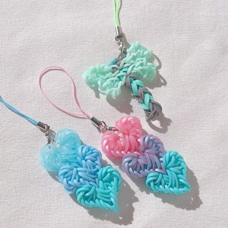 two heart shaped earrings are shown on a white surface with blue, pink and green beads