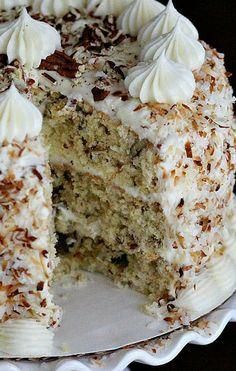 a cake with white frosting and coconut on top