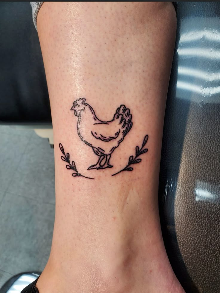 a chicken tattoo on the ankle