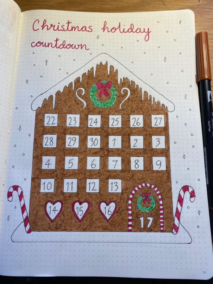 a christmas holiday calendar with gingerbread house and candy canes on the page, next to a pen