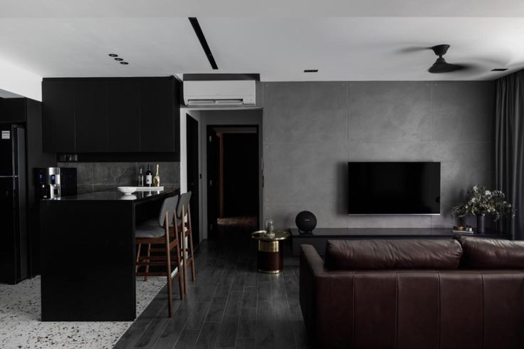 a living room filled with furniture and a flat screen tv on top of a wall