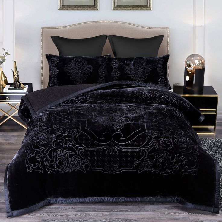 a bed with black comforters and pillows in a room