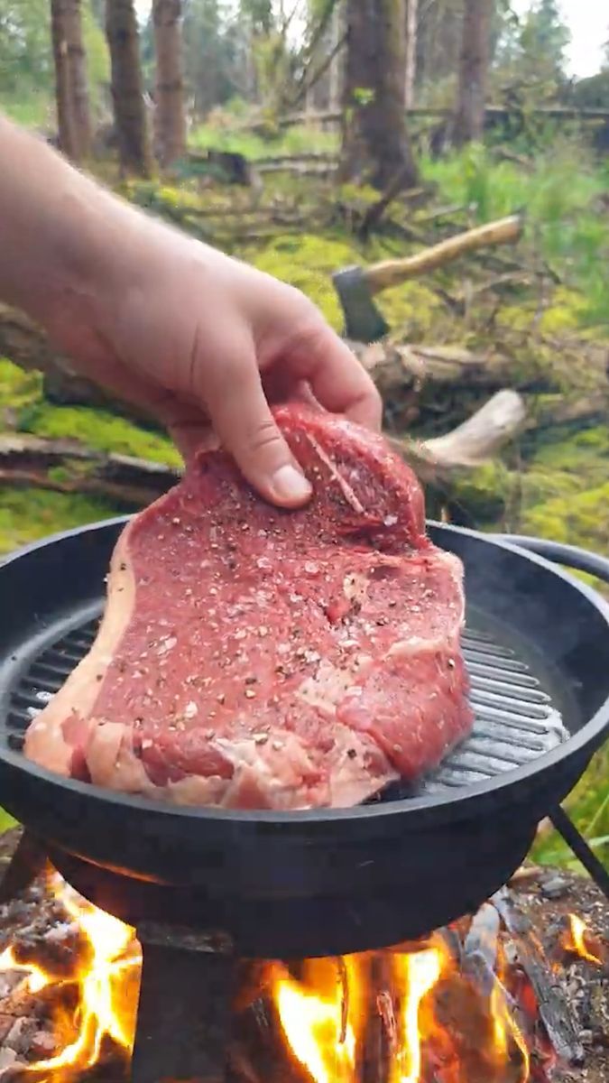 a person is grilling meat over an open fire