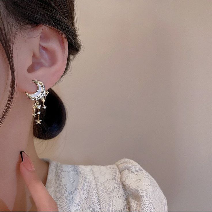 Hello beautiful! The Moon Star Tassel Earrings feature a mesmerizing moon stud, with a white resin inlay, an outline encrusted in CZ's, and three starry tassels, the innermost set as a dangling charm. These celestial beauties are out of this world! DETAILS & SIZE Finish: Gold plate Materials: Zinc alloy; resin; CZ crystals Measurements: Length: approx. 2" Comes with friction earring backs Shop the Celestial collection for more options! Or shop Earrings for more options! Moon Stud Earrings, Celestial Star-shaped Earrings With Sun And Moon Design, Mystical Moon-shaped Pierced Earrings, Celestial Moon-shaped Crystal Earrings As Gift, Luxury Moon-shaped Celestial Earrings, Celestial Gold Moon-shaped Crystal Earrings, Moon And Star Earrings, Gold Moon, Waterproof Jewelry