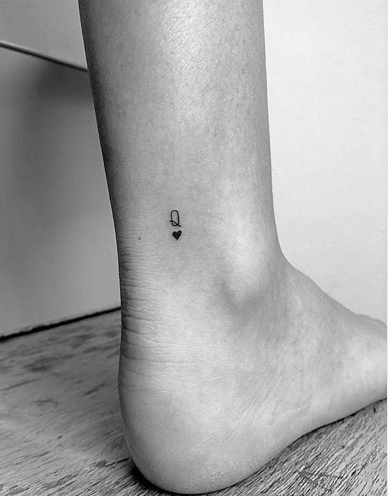 a black and white photo of a person's foot with a small tattoo on it