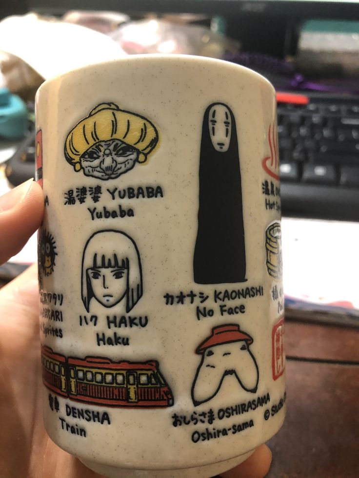 a hand holding a coffee cup with some stickers on it