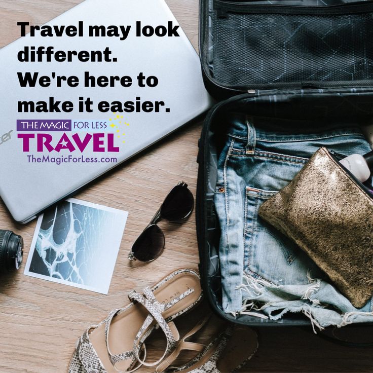 an open suitcase sitting on top of a wooden floor next to sunglasses and other items