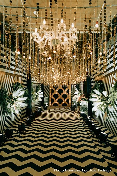 an elaborately decorated hall with chandeliers and black and white striped flooring