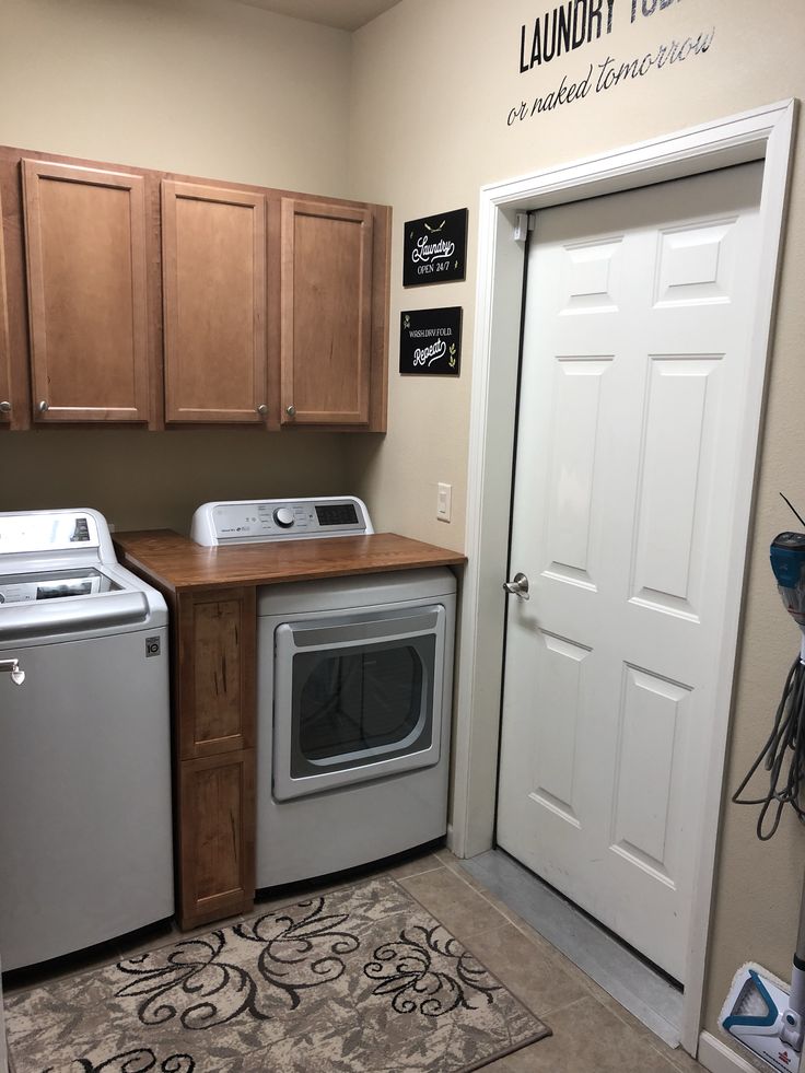 a washer and dryer sitting in a laundry room next to a white door