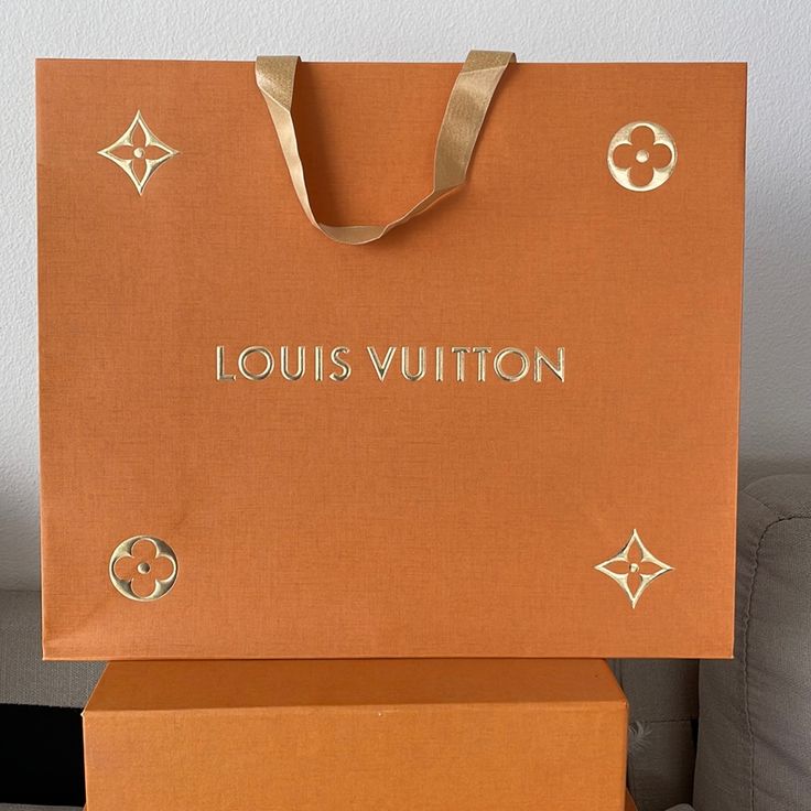 an orange louis vuitton bag sitting on top of a box