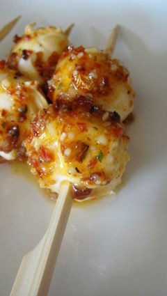 some food is on a white plate with a wooden skewer in front of it