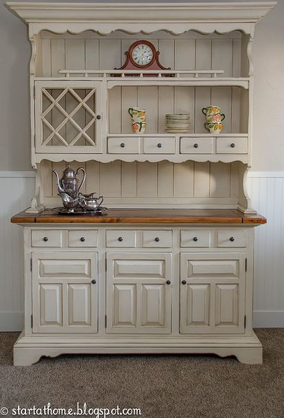 an old white china cabinet with wooden top