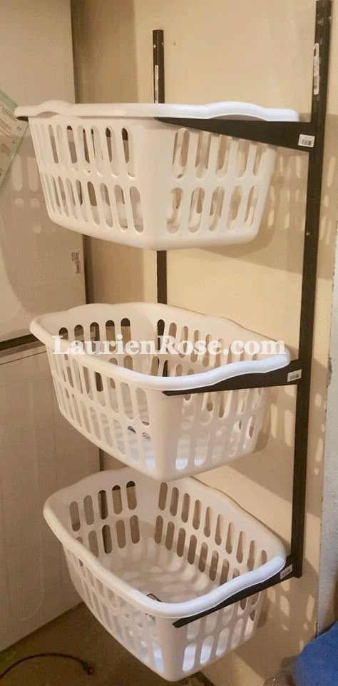 three white laundry baskets sitting on top of a metal rack