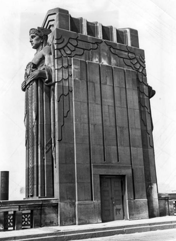 an old black and white photo of a building with a statue on the top of it