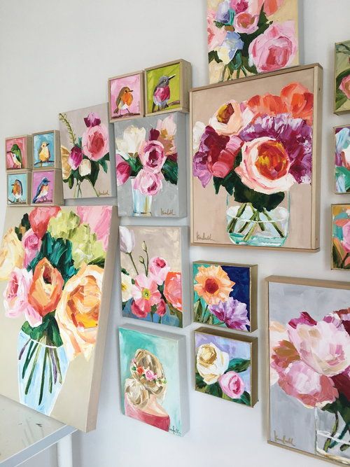 a bunch of flowers are hanging on the wall next to some framed pictures and vases