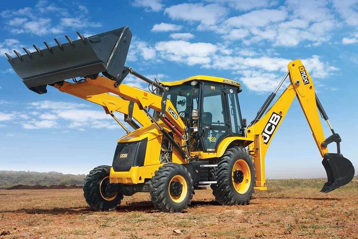 a yellow tractor is parked in the dirt