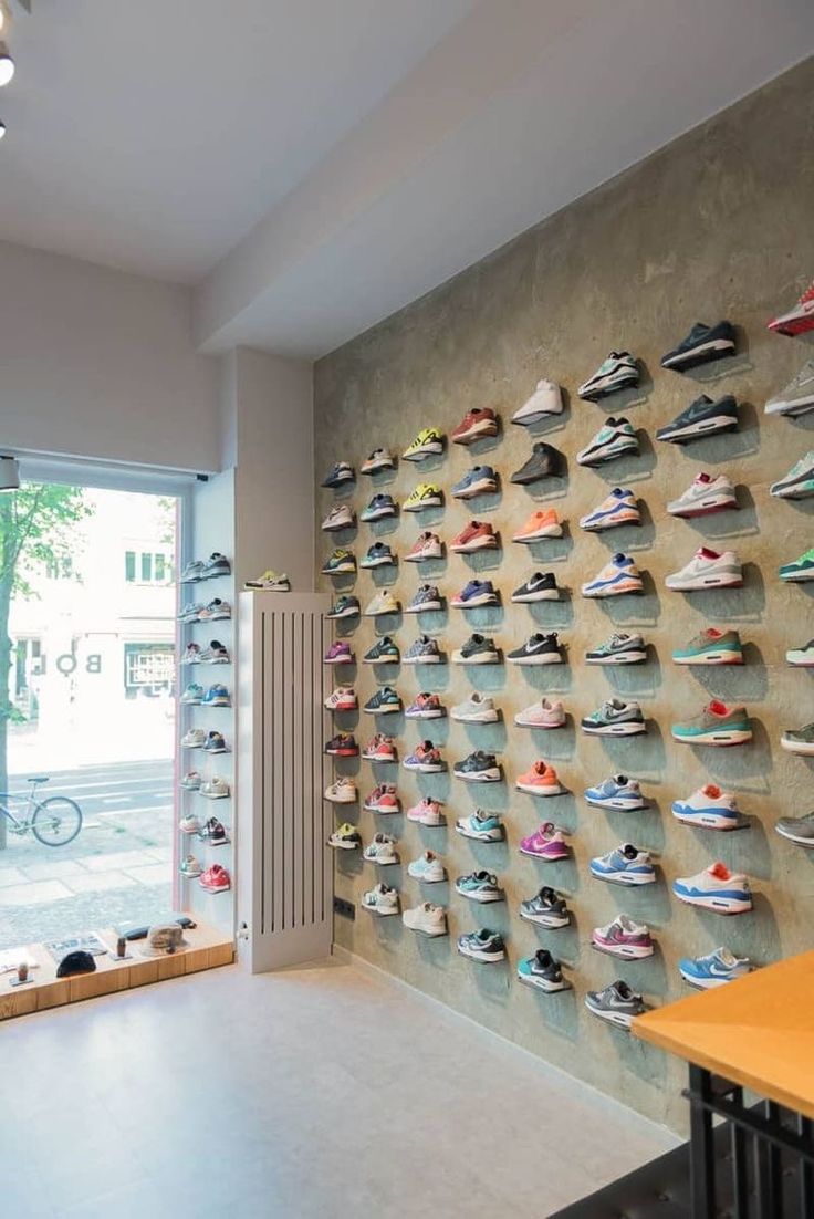 there is a wall with many pairs of shoes hanging on the wall and in front of it