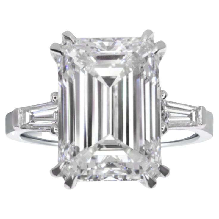 Indulge in the allure of sophistication with this captivating ring, where a magnificent 5-carat emerald-cut diamond takes center stage. The G color and VVS2 clarity of the diamond contribute to its exceptional brilliance and purity, making it a testament to refined elegance. Flanking the stunning emerald-cut diamond are two tapered baguette diamonds, adding a touch of modernity to the timeless design. These diamonds, with their sleek and elongated profile, perfectly complement the central gem, creating a harmonious ensemble of classic and contemporary elements. Set in a lustrous 18K gold setting, this ring is a masterpiece of craftsmanship and luxury. The warm tones of the gold provide a rich backdrop for the diamonds, enhancing their sparkle and creating a piece that exudes both opulence Estate Diamond Jewelry, Rare Diamond, Brilliant Cut Diamond Ring, Spiritual Wallpaper, Contemporary Engagement Rings, Emerald Cut Diamond Ring, Platinum Diamond Rings, Modern Engagement Rings, Emerald Cut Diamond