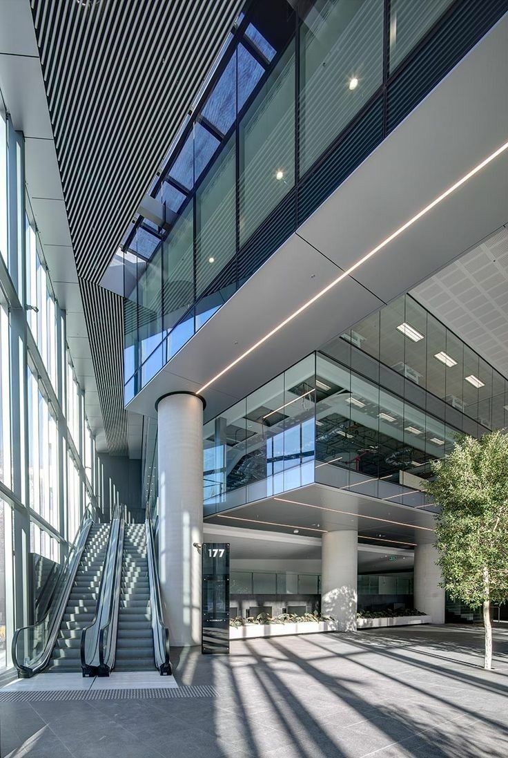 the inside of an office building with glass walls and stairs leading up to it's second floor